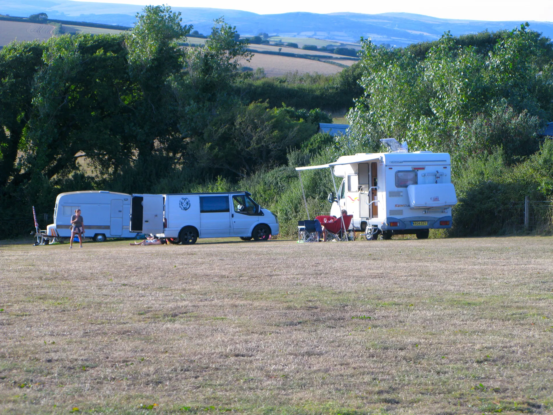 Campervan and caravan pitched with countryside views