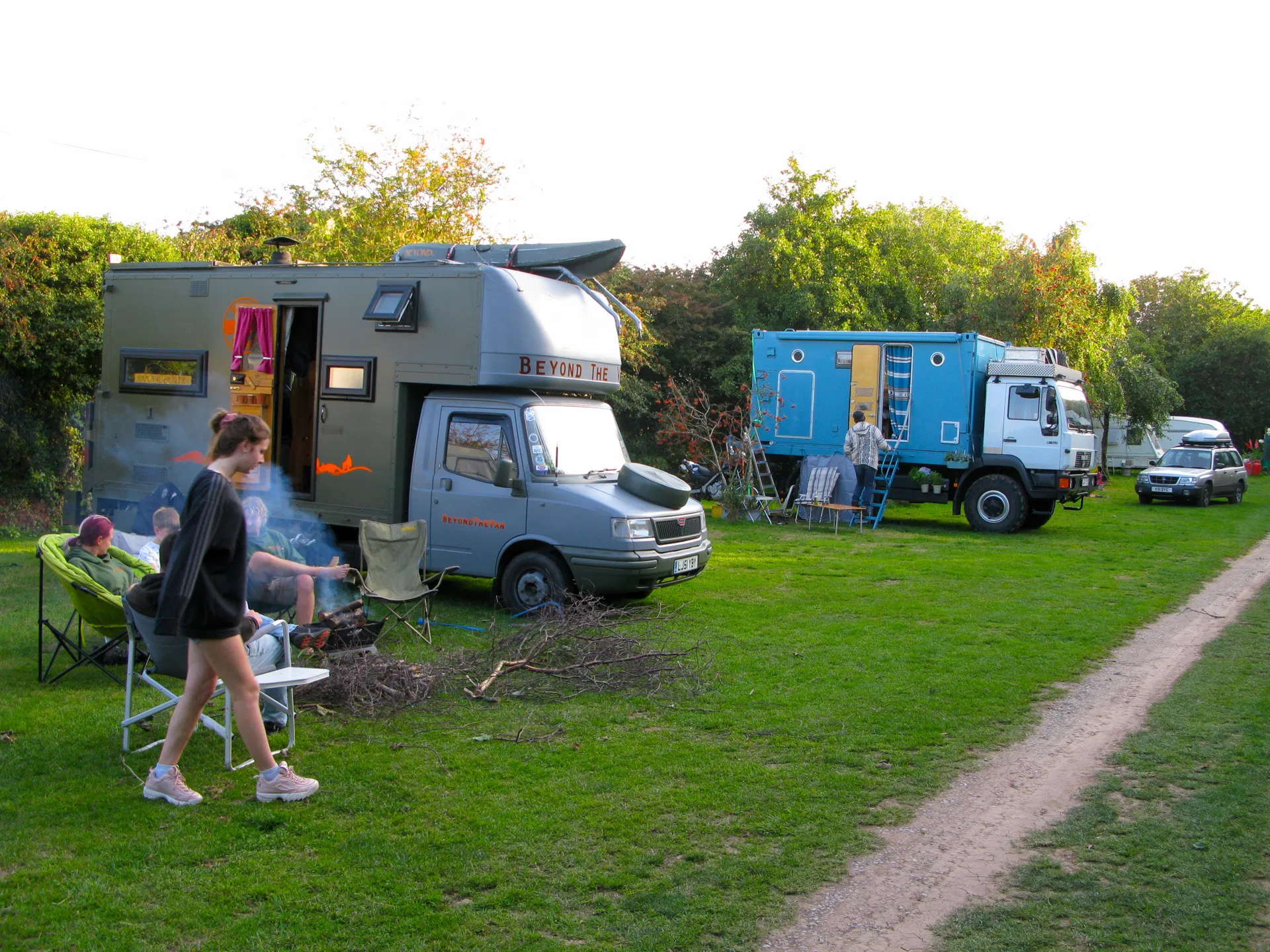 Classic overland trucks pitched among the trees