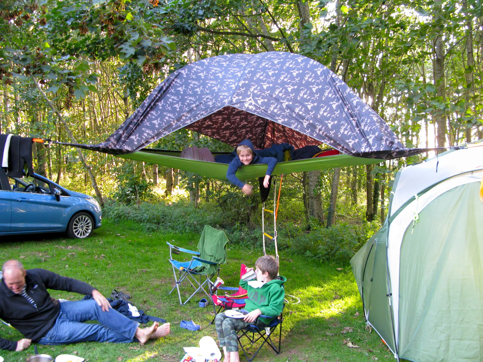 Children playing in a hammock tent strung between the trees